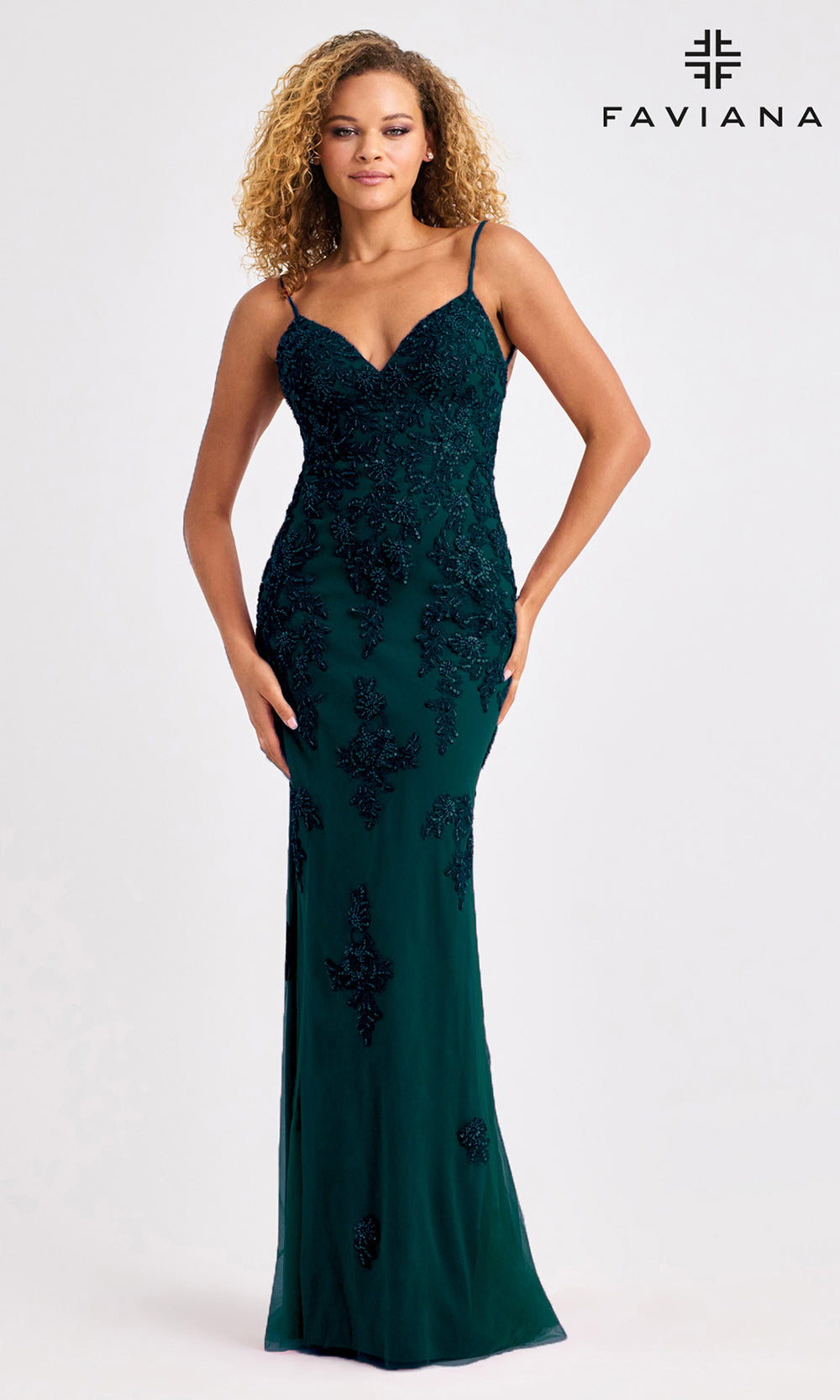 Woman wearing a green evening gown with floral embroidery on a white background, branded 'Faviana'.