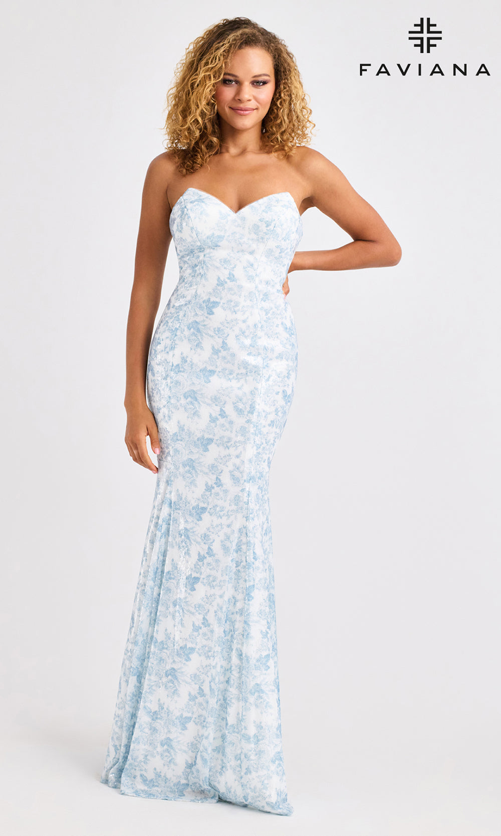 Woman wearing a strapless floral gown with Faviana branding on a white background