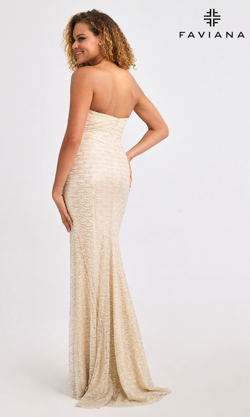Woman wearing a strapless, long, beige evening gown on a white background with Faviana branding.