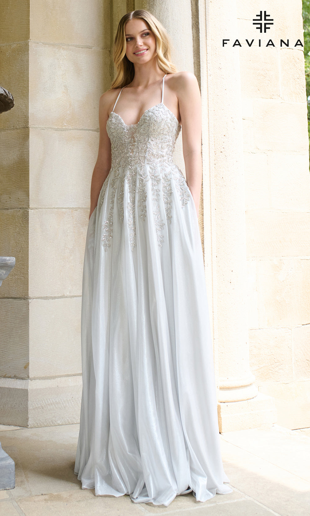 Woman wearing a white evening gown with a visible 'Faviana' brand logo.