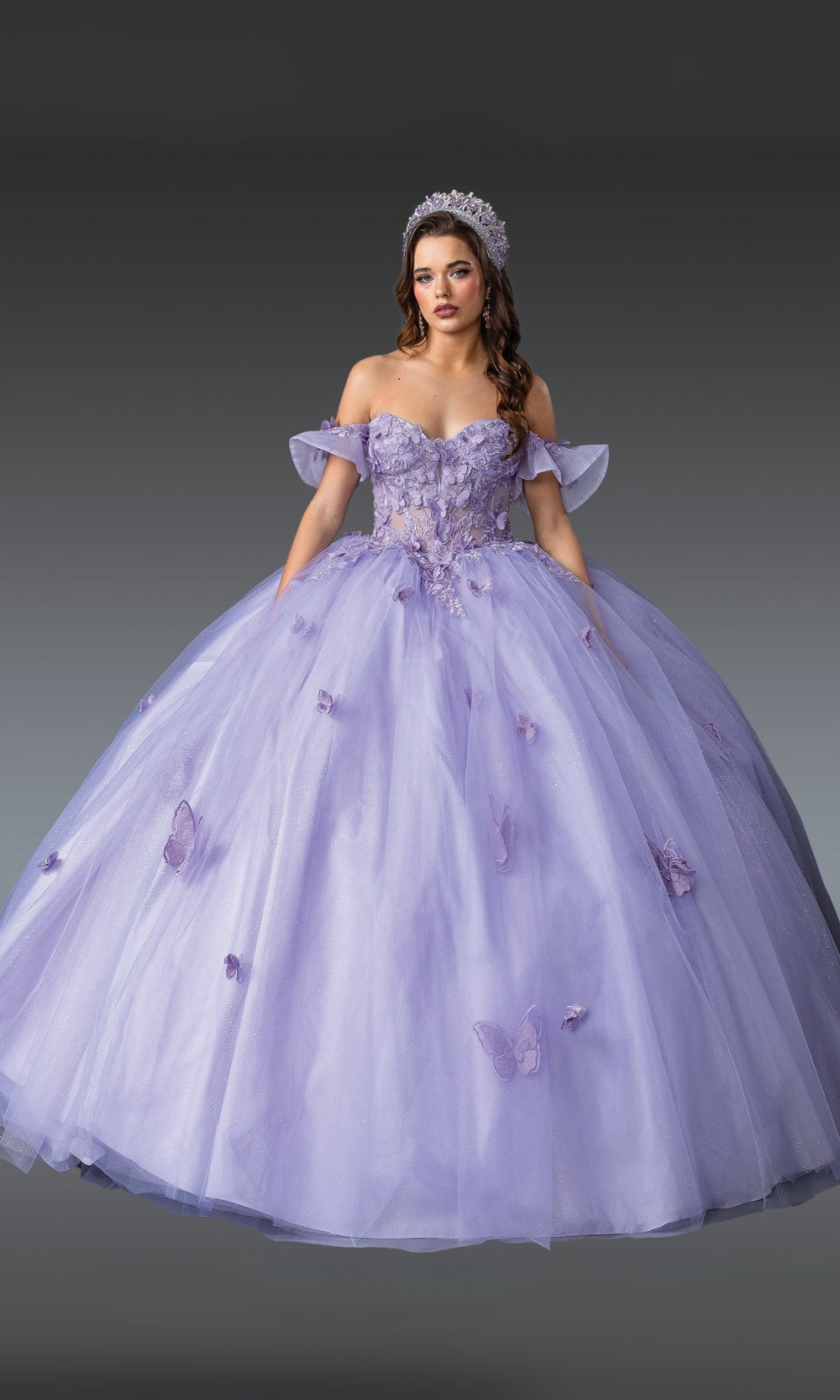 Woman wearing a purple ball gown with butterfly details on a gray background