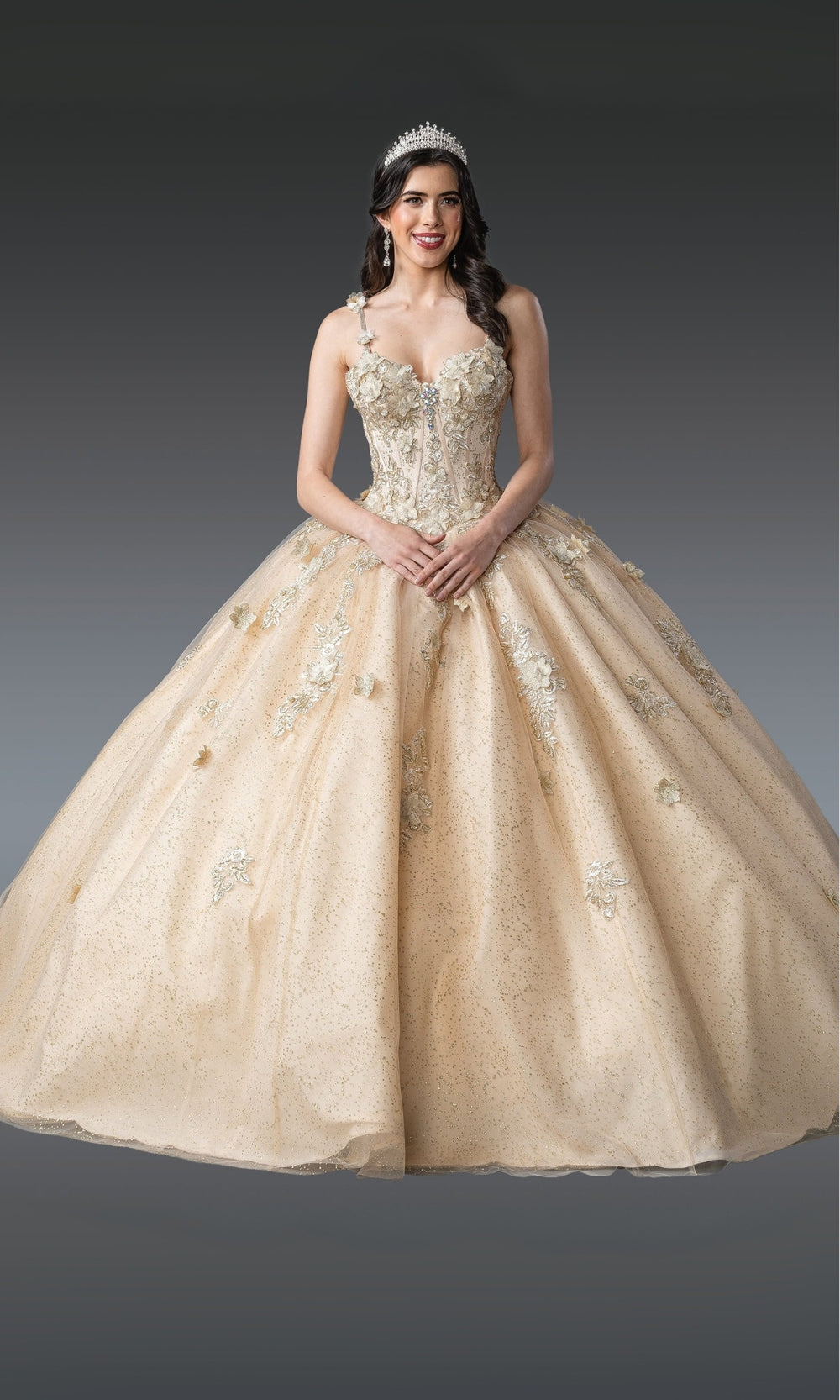 Woman wearing a beige ball gown with floral details on a gray background