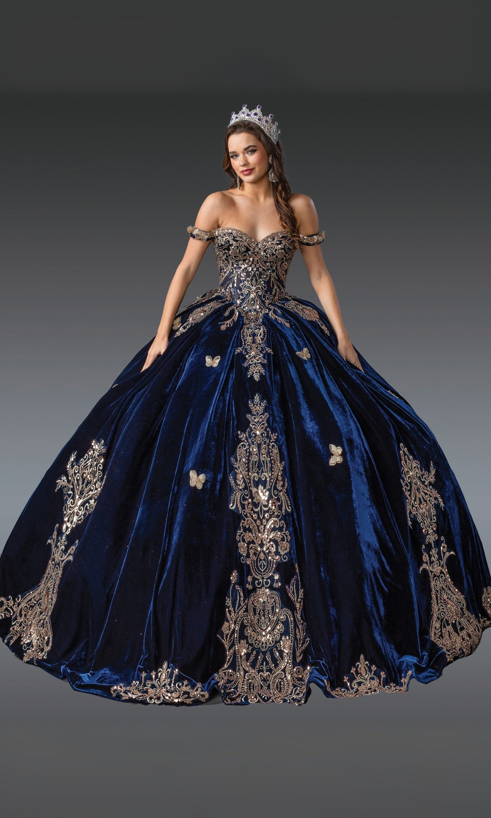 Navy blue gown with intricate gold embroidery and a tiara on a gradient background