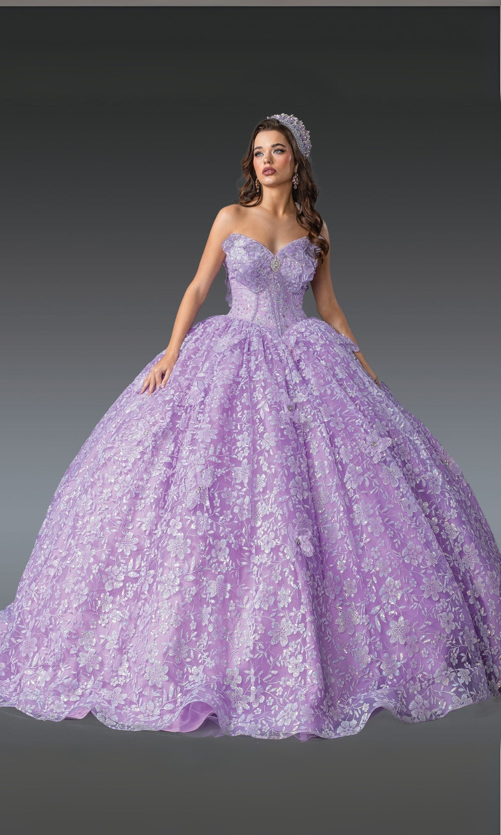 Woman wearing a purple ball gown with floral details on a gray background