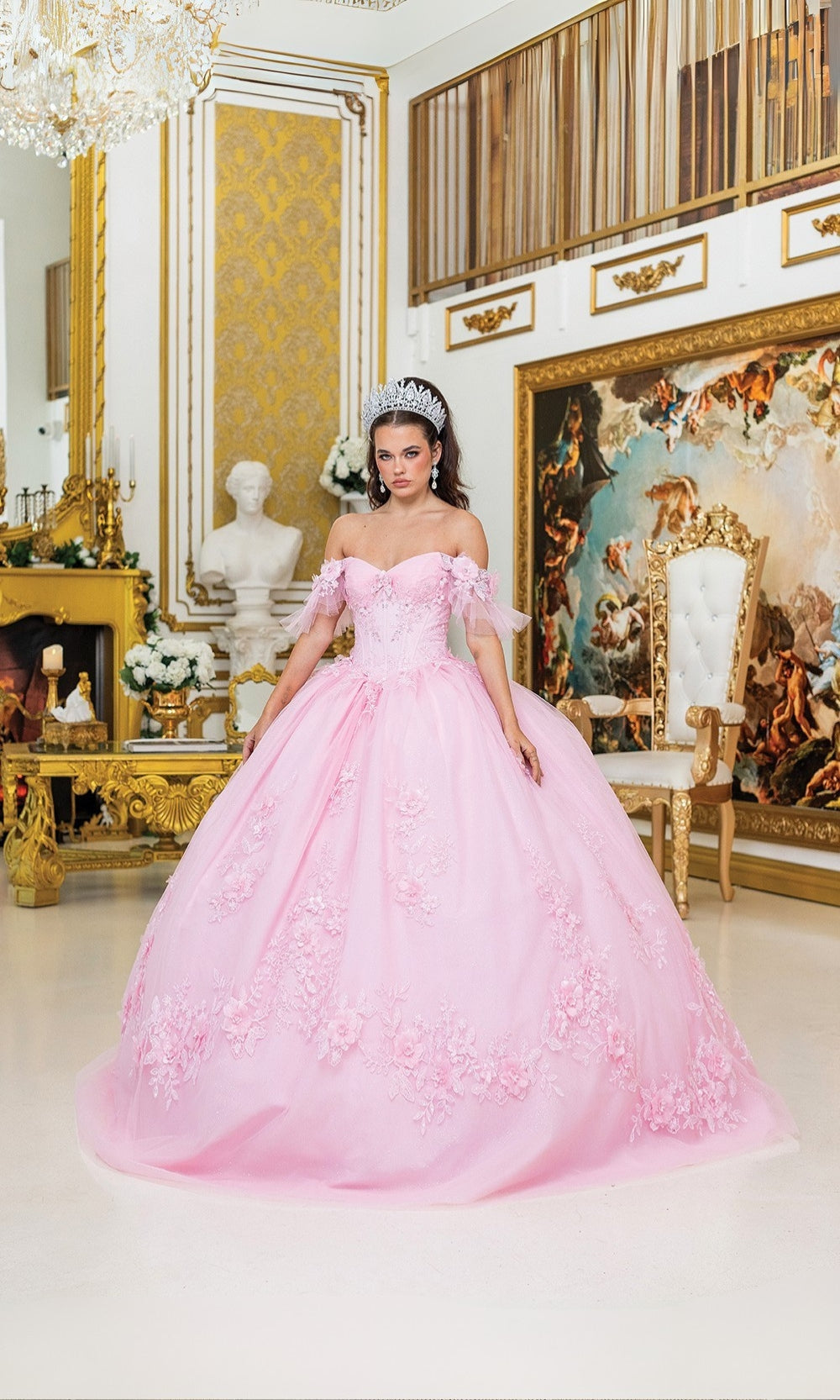 Woman in a pink gown standing in an ornate room with gold accents and artwork.