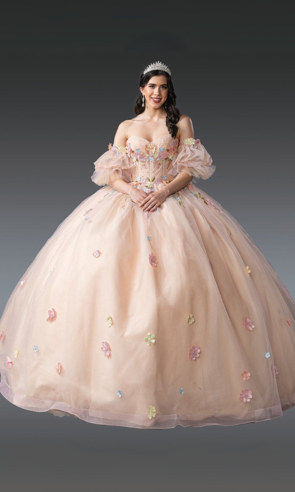 Woman in a beige ball gown with floral embroidery on a dark background