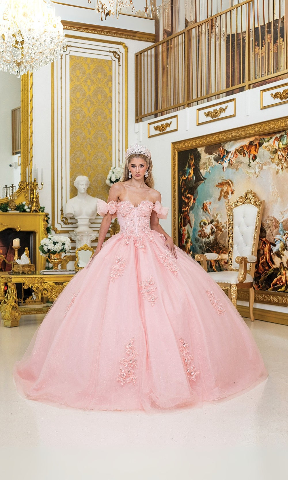 Woman in a pink gown standing in an opulent room with gold decor and artwork.