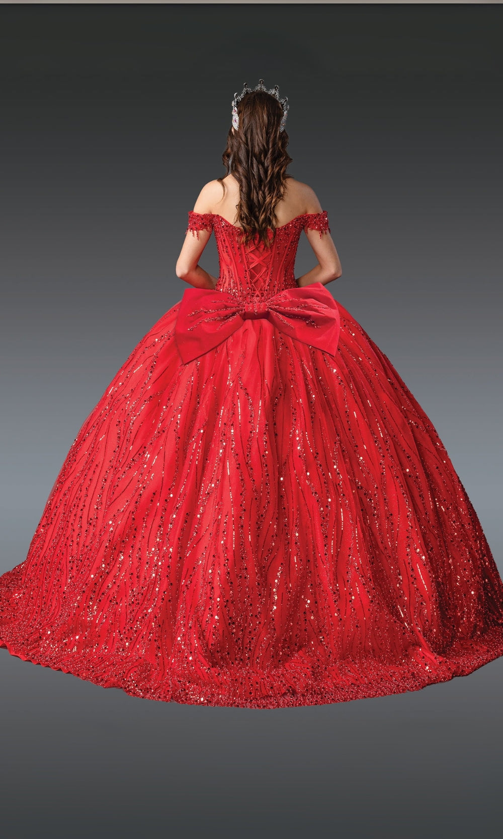 Red ball gown with a large bow on a dark background