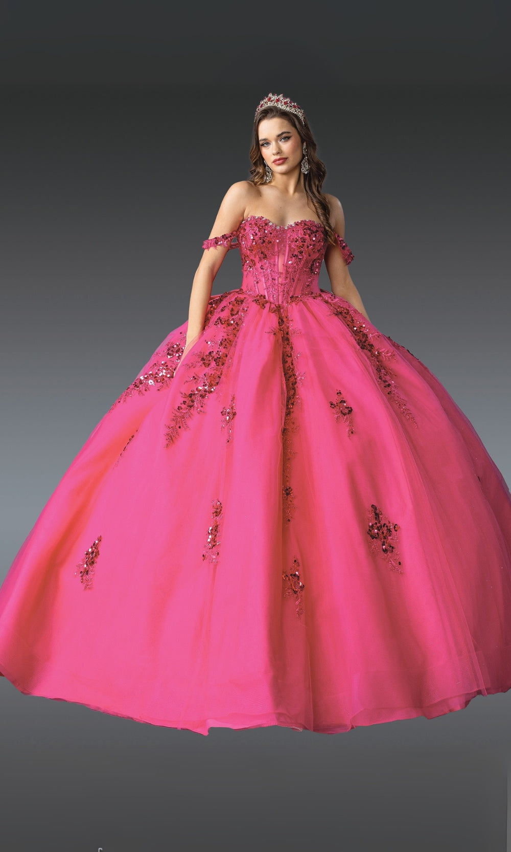 Pink ball gown with floral embellishments on a gray background