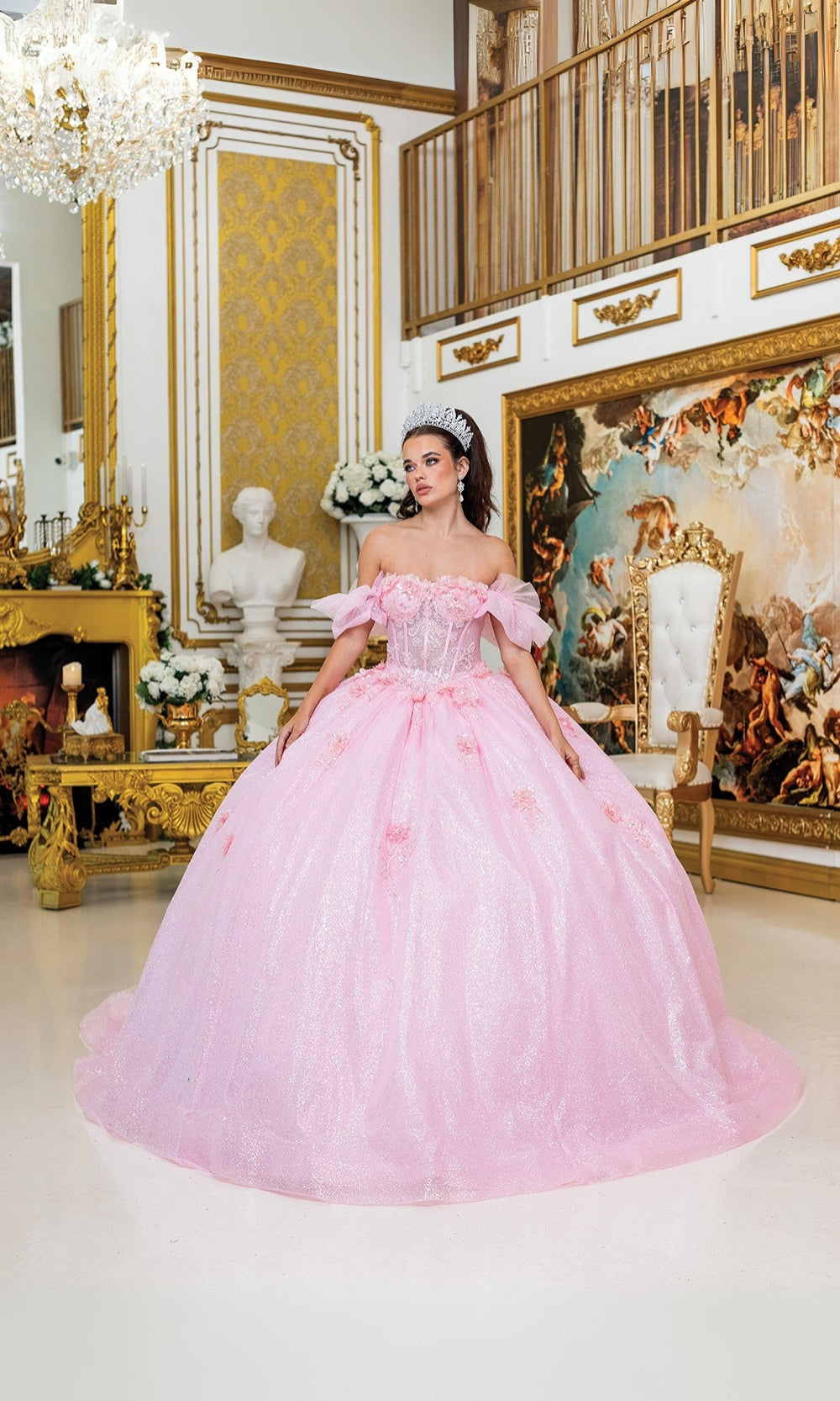 Woman in a pink dress standing in an ornate room with gold accents and artwork.