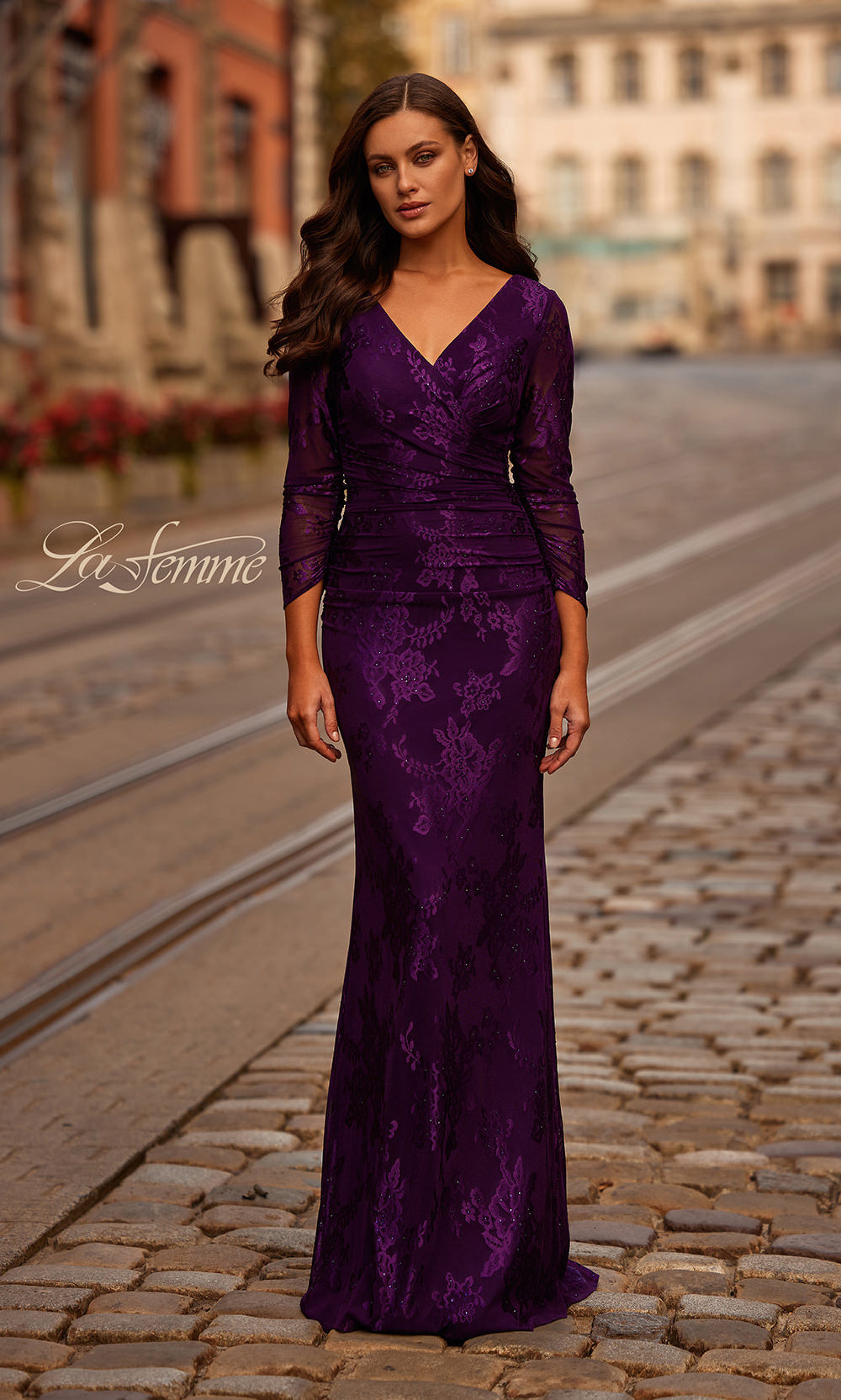 Woman wearing a purple evening gown on a city street with 'La Femme' branding.