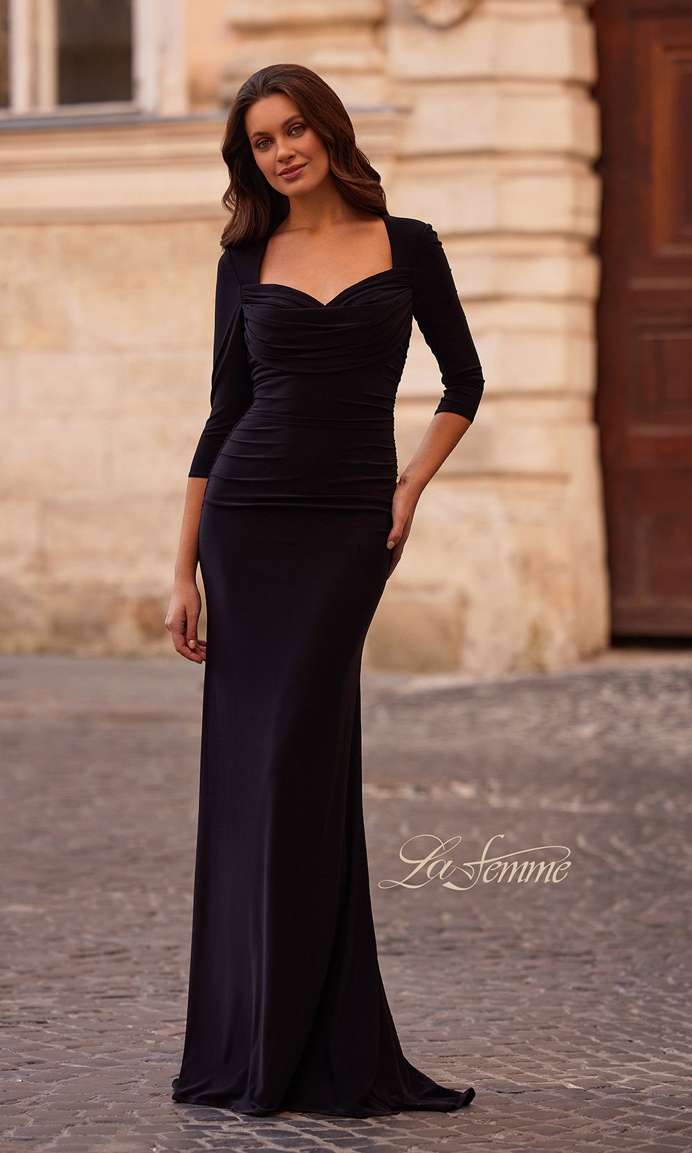 Woman wearing a black evening gown with a building in the background