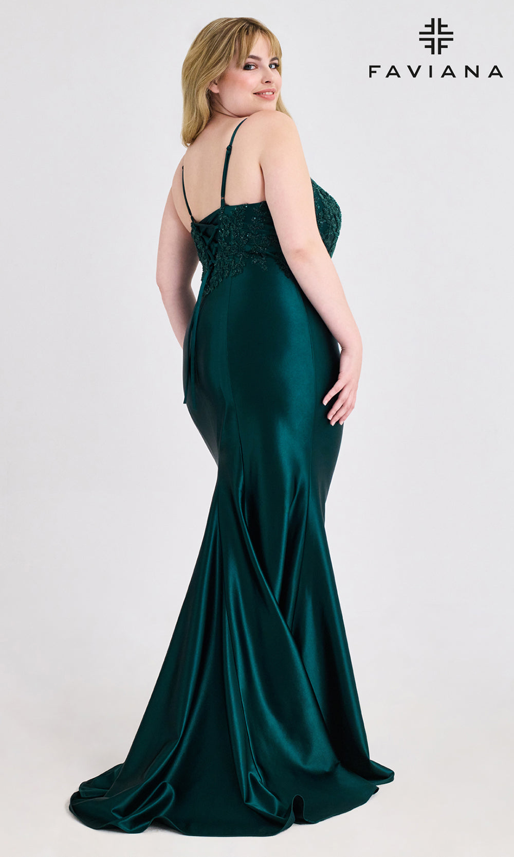 Woman wearing a green evening gown with lace detailing, branded 'Faviana', on a white background.
