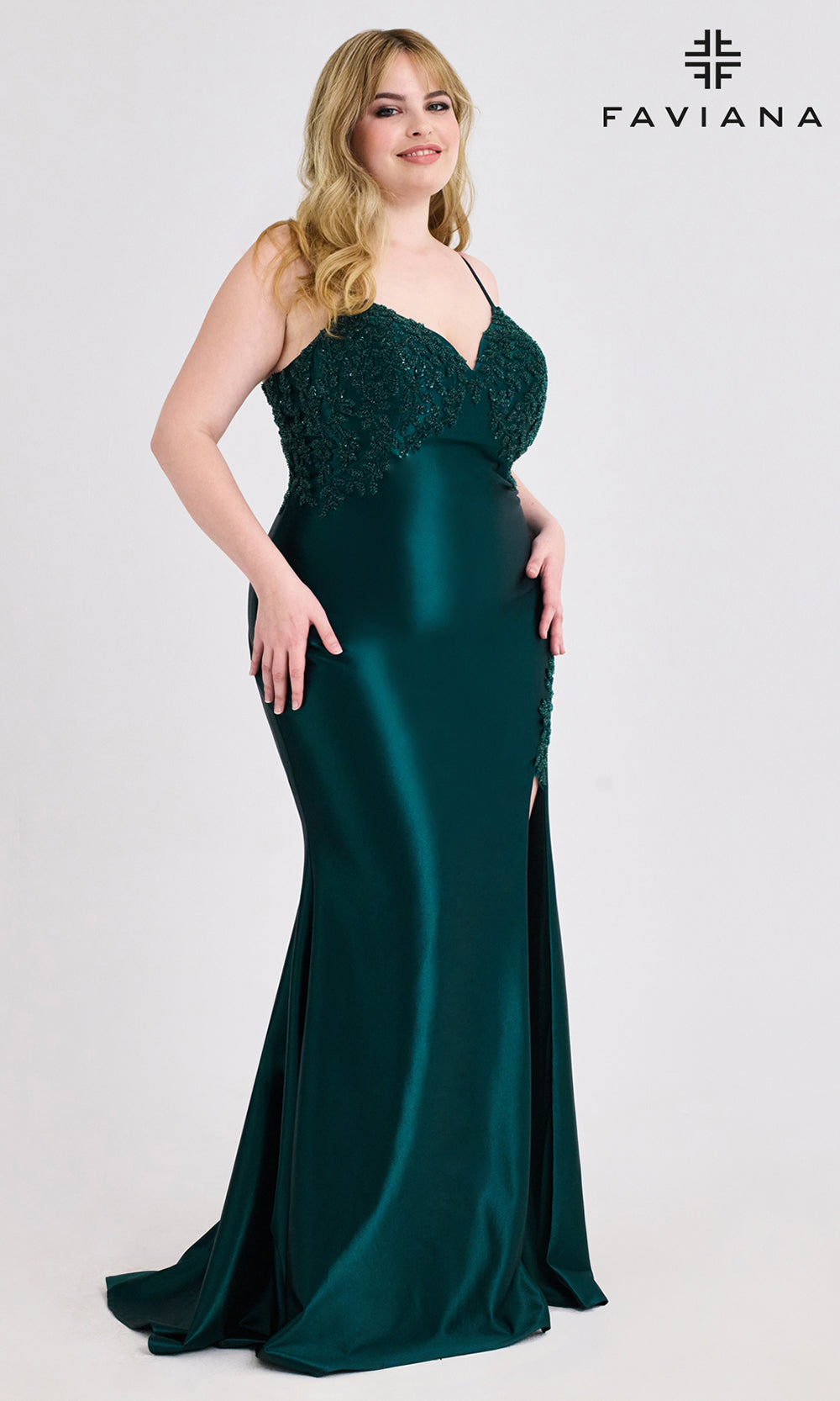Woman wearing a green evening gown with a slit, standing against a white background with 'Faviana' branding.