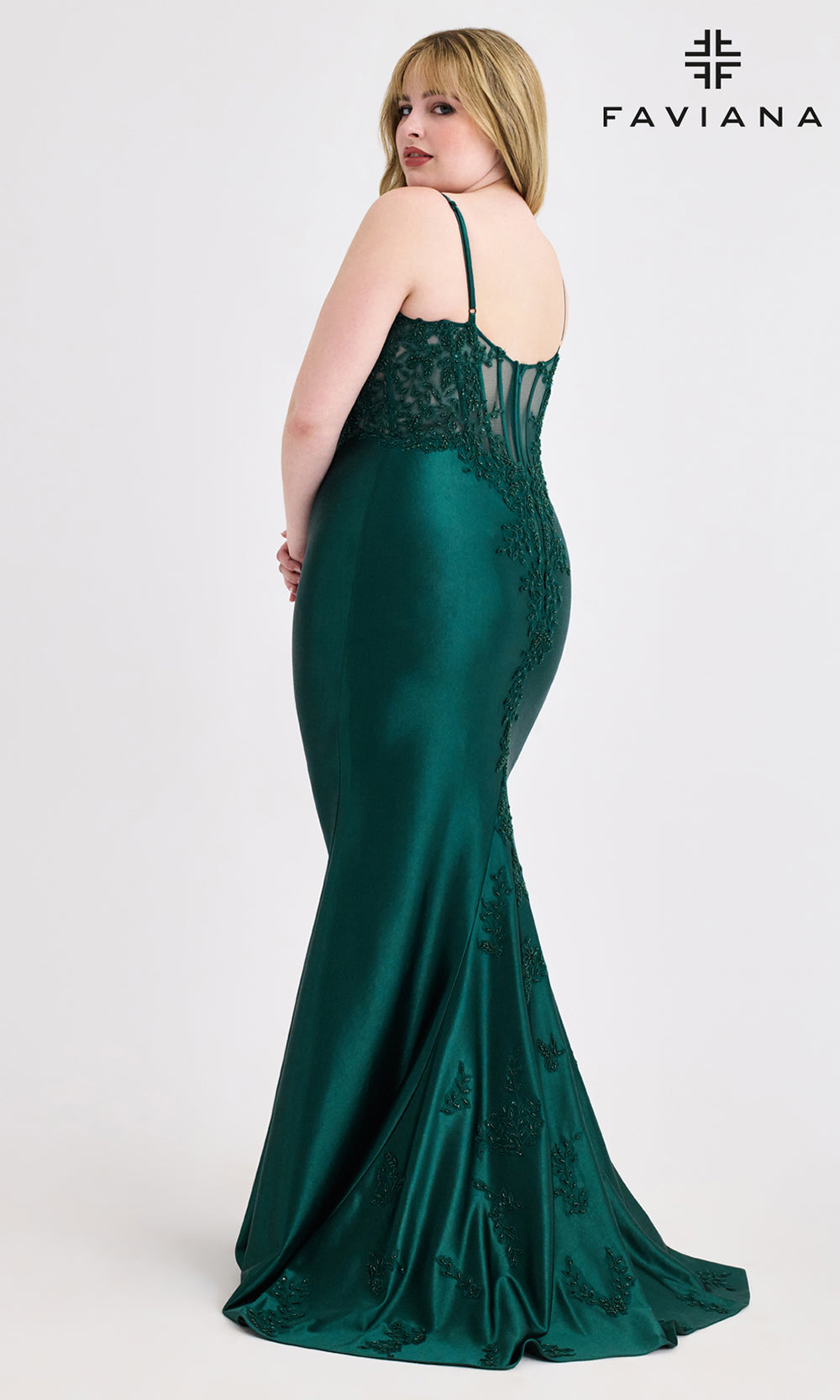 Woman wearing a green evening gown with lace detailing, branded 'Faviana', on a white background.