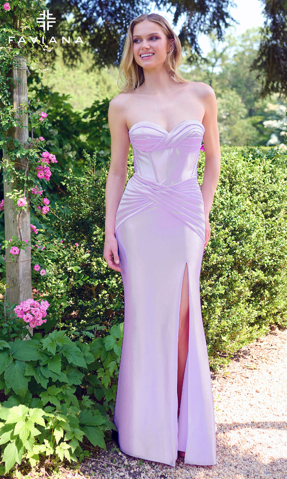Woman in a strapless lavender gown with a high slit standing in a garden setting.