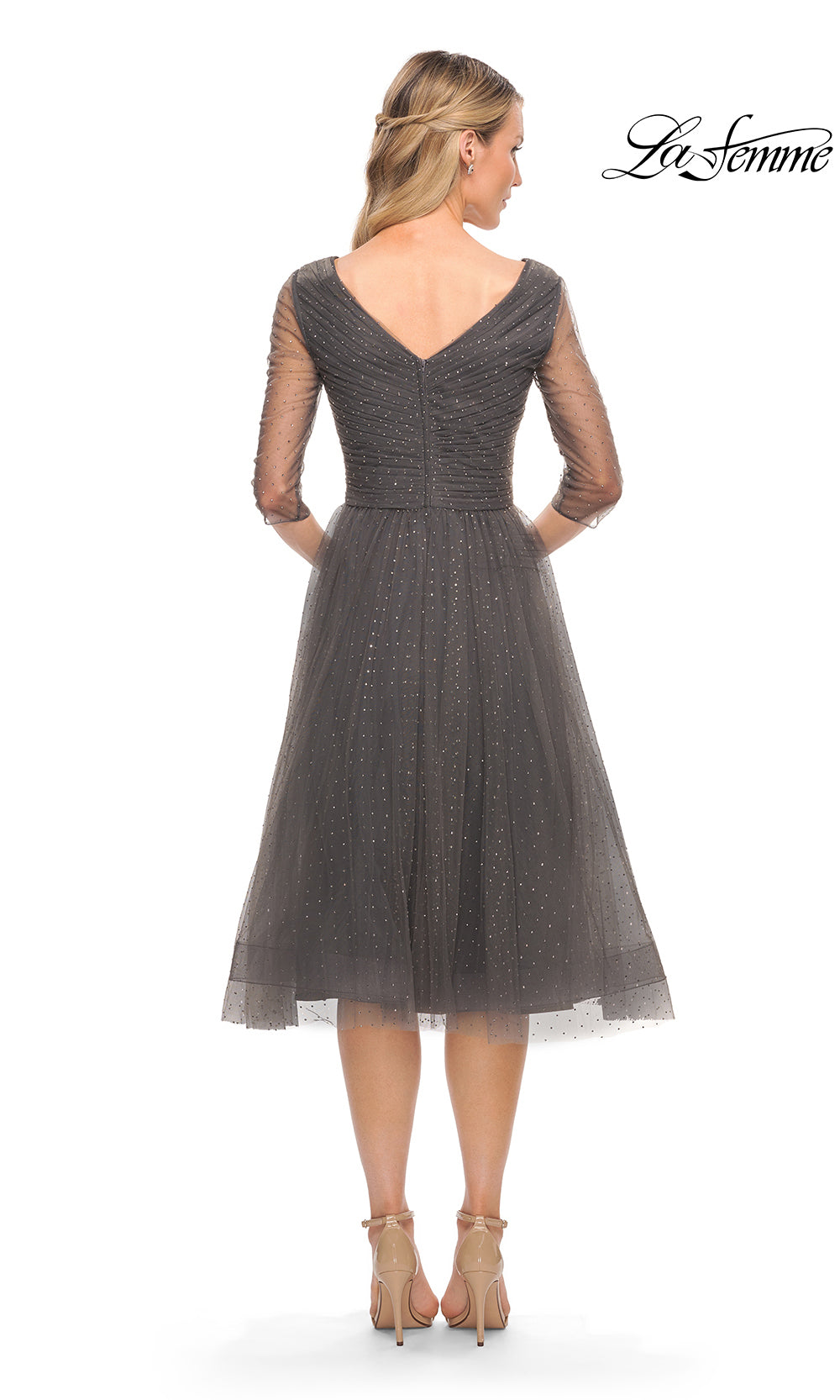 Woman wearing a gray dress with a subtle pattern on a white background