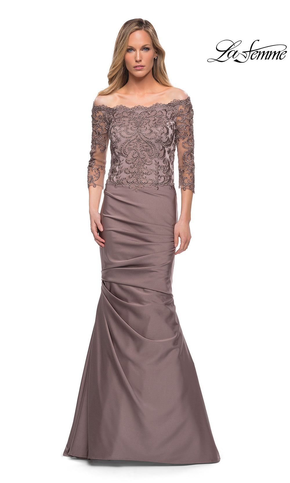 Woman wearing a brown off-shoulder gown with lace detailing on a white background