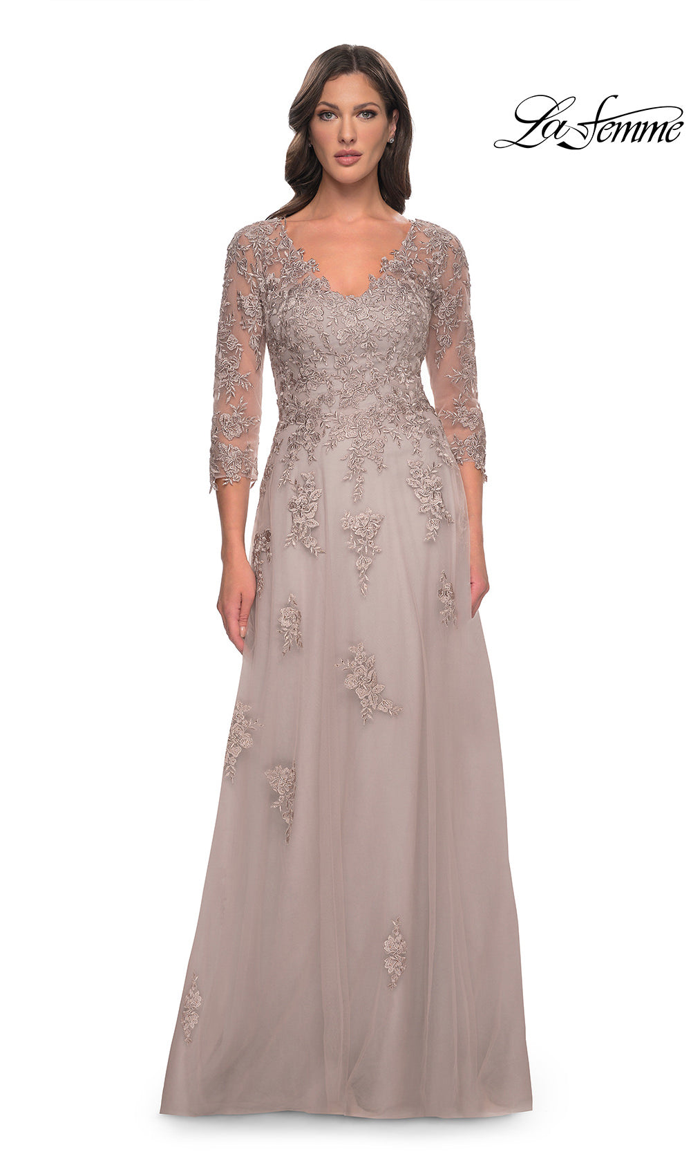 Woman wearing a long, elegant dress with lace detailing on a white background