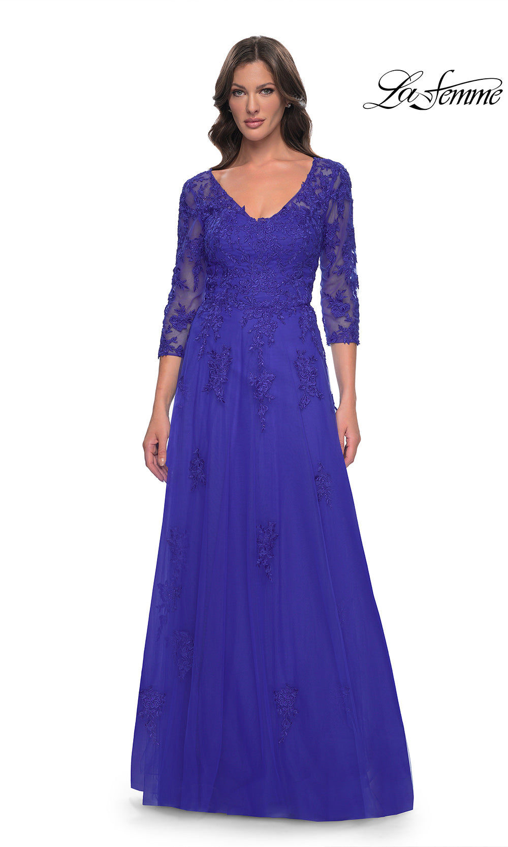 Woman wearing a blue evening gown with lace detailing on a white background