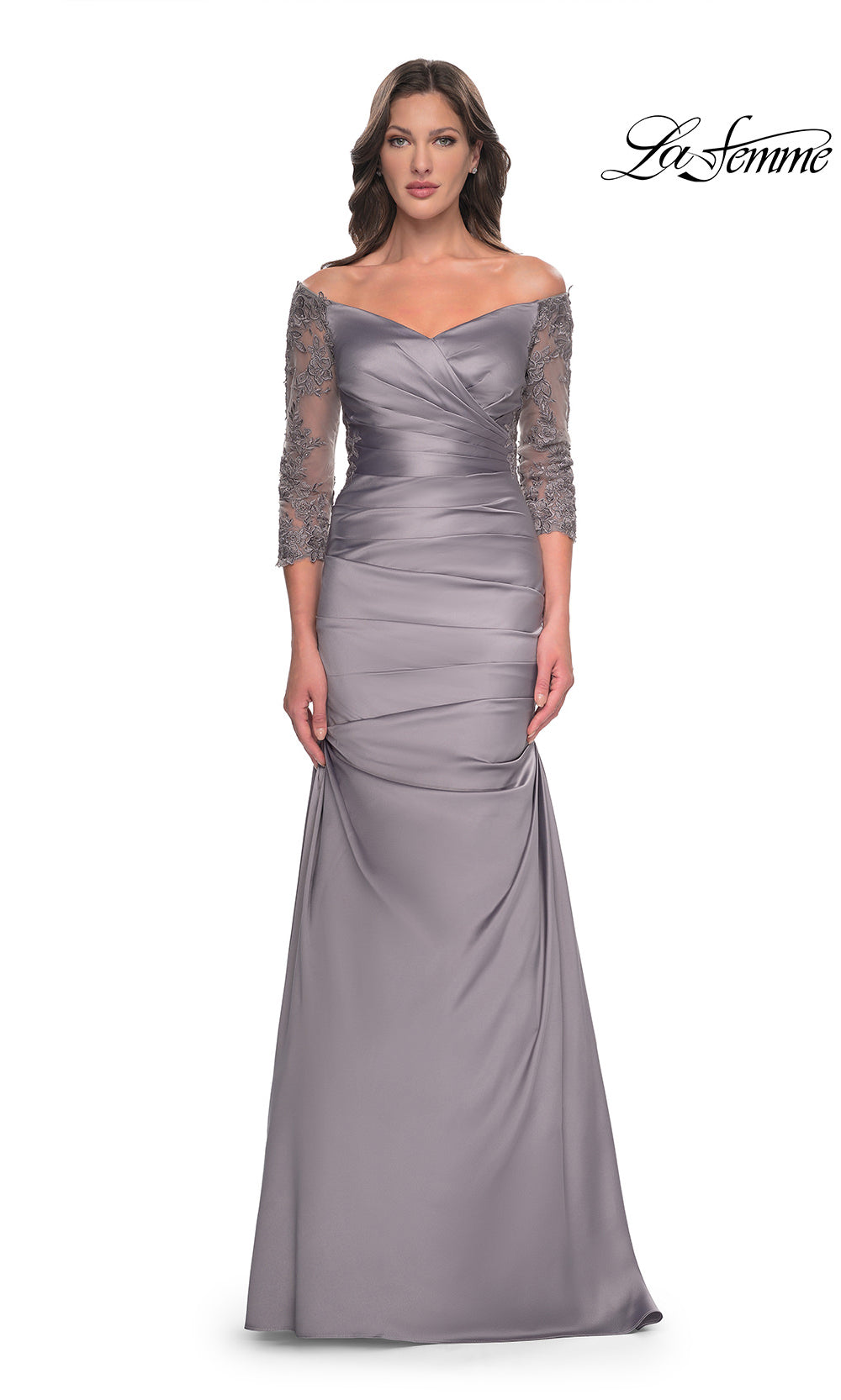 Woman wearing a silver evening gown with lace sleeves on a white background