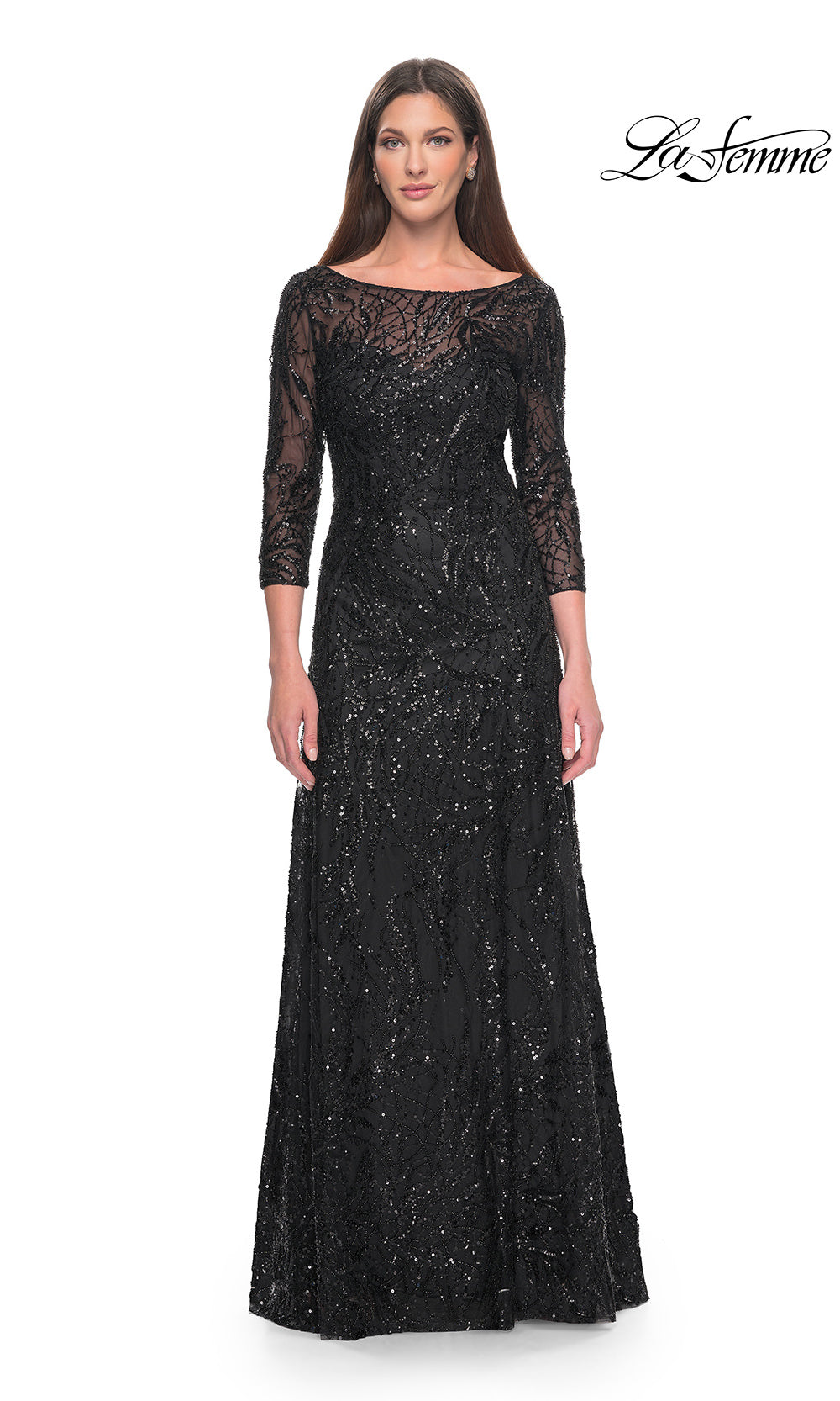 Woman wearing a black evening gown with lace detailing on a white background