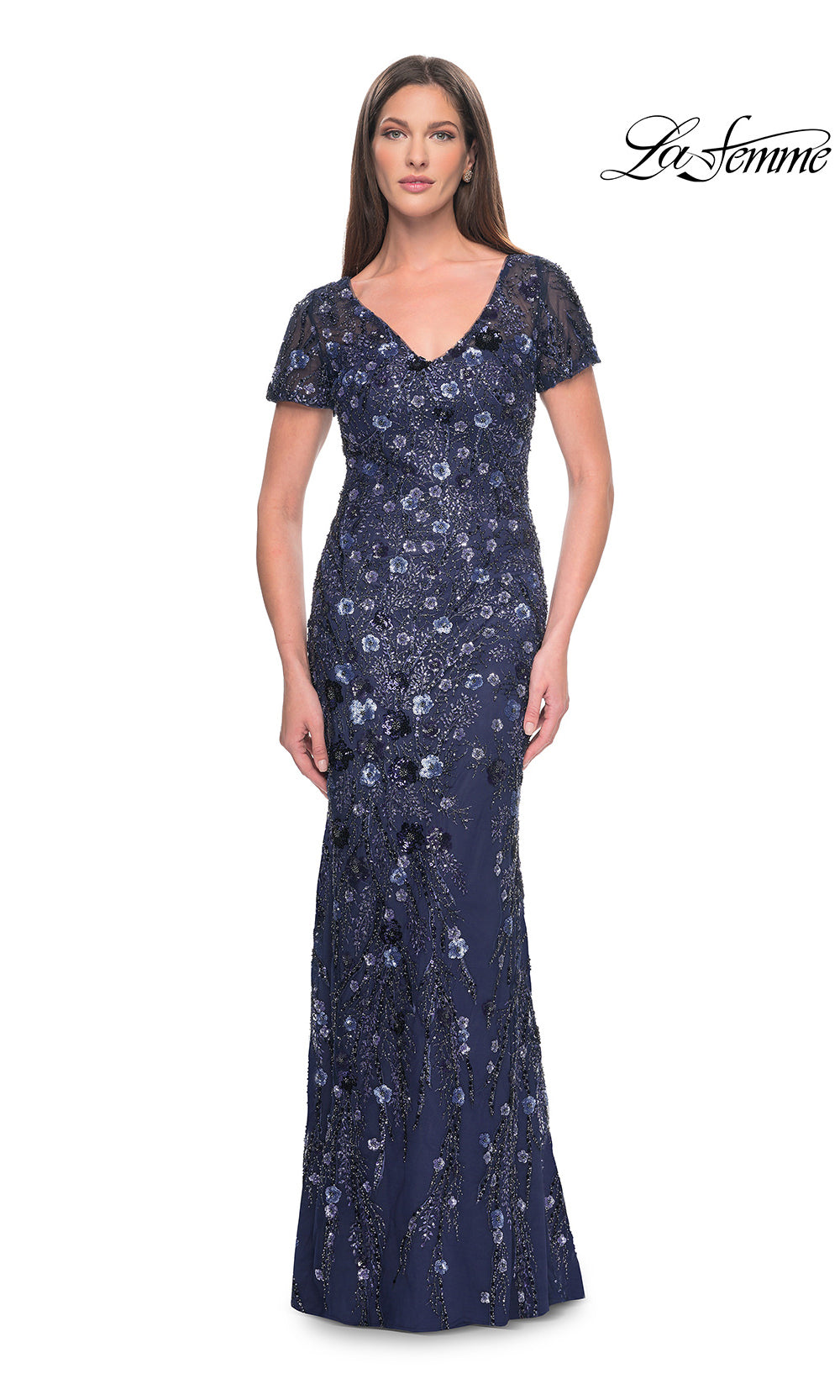 Woman wearing a navy blue evening gown with lace details on a white background