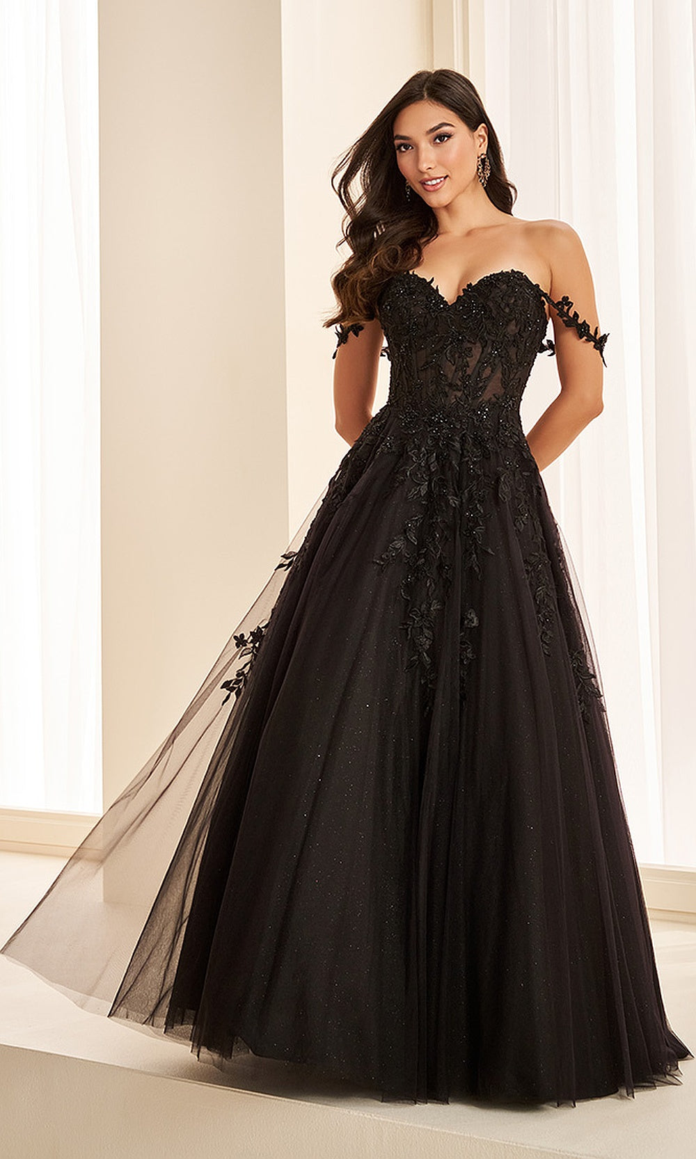 Ellie Wilde EW37028 Black prom dress front view with glitter tulle, floral appliqués, off-shoulder sweetheart neckline, corset ballgown silhouette, formal prom gown.