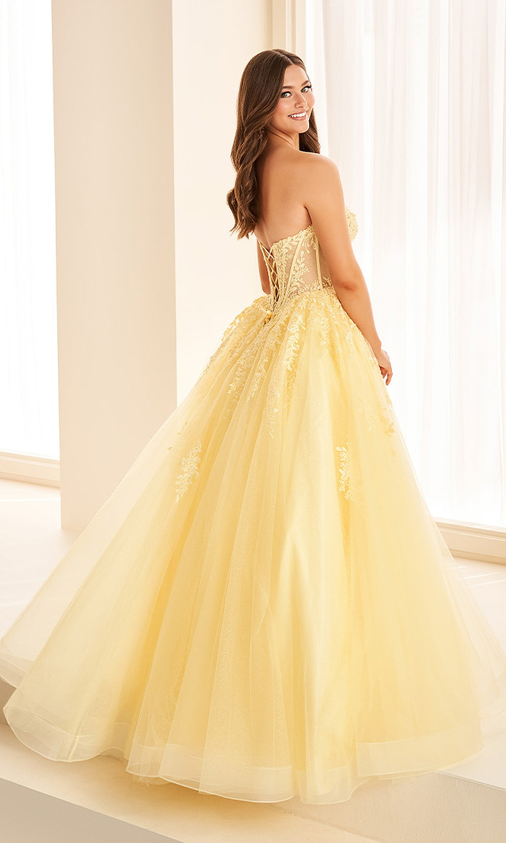 Ellie Wilde EW38018 Light Yellow prom dress back view with corset lacing, beaded lace tulle ballgown silhouette, floral appliques, and boning for an elegant evening gown.