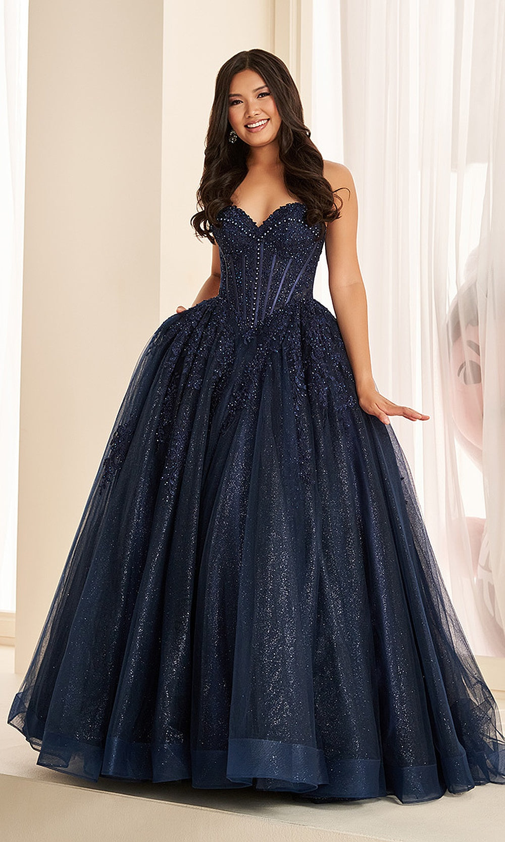 Ellie Wilde EW38018 Navy Blue prom dress front view with beaded lace over glitter tulle, strapless sweetheart corset ballgown silhouette, and floral appliques for a gala gown.