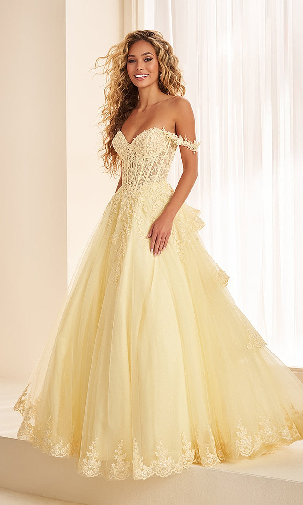 Ellie Wilde EW38092 Light Yellow prom dress front view with glitter tulle, floral appliques, sweetheart corset bodice, and tiered ballgown skirt for a formal prom gown.