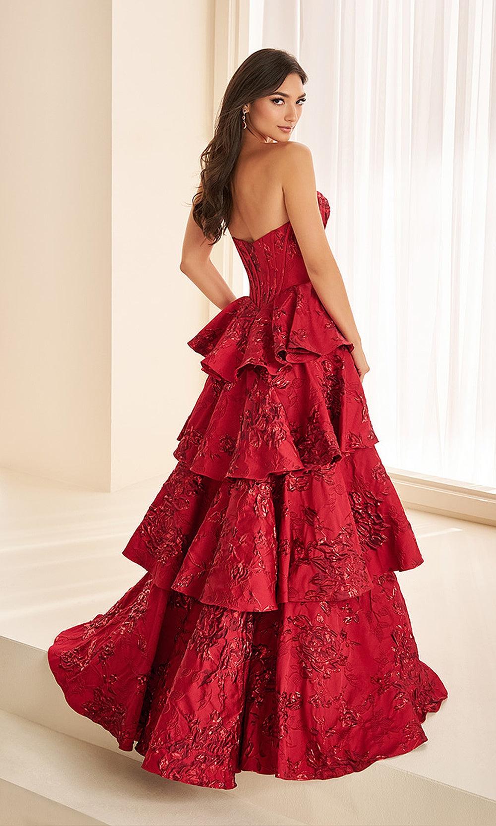 Ellie Wilde EW38098 Red prom dress back view with metallic print fabric, open-back boned corset bodice, ballgown silhouette with ruffled train, evening gown.