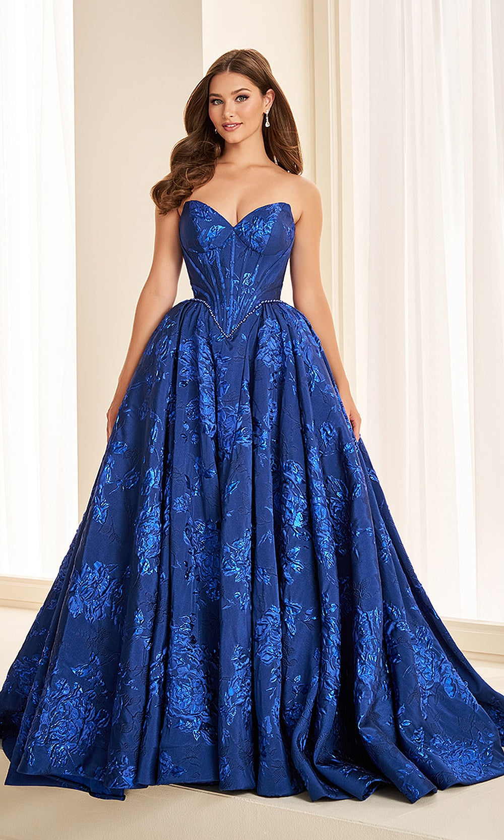 Ellie Wilde EW38100 Royal Blue prom dress front view with jacquard print fabric, strapless sweetheart neckline, boned corset bodice, and full ballgown silhouette, gala gown.