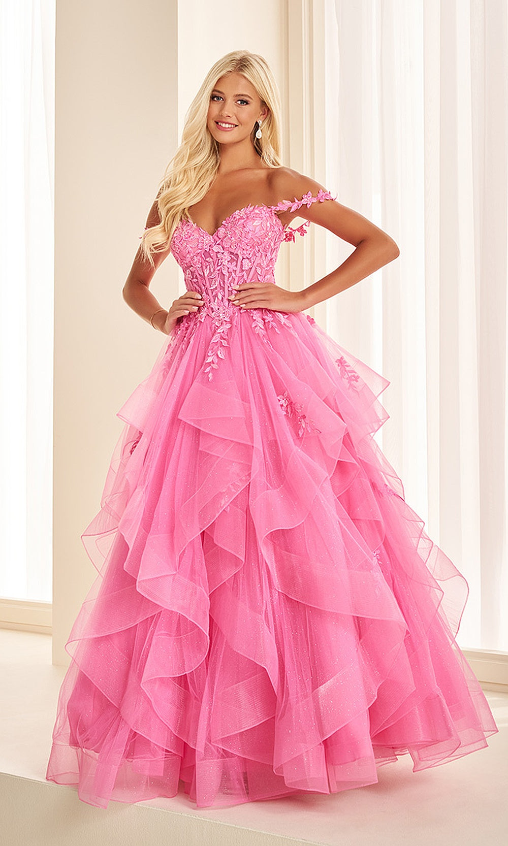 Ellie Wilde EW38220 Hot Pink off-shoulder corset prom dress front view with glitter tulle and lace, floral appliques and beading, ballgown silhouette, gala gown.
