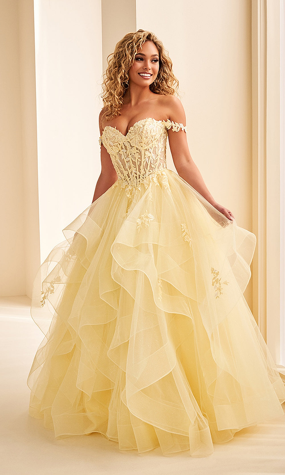 Ellie Wilde EW38220 Light Yellow off-shoulder corset prom dress front view with glitter tulle, floral appliques and beading, ballgown silhouette, formal prom gown.