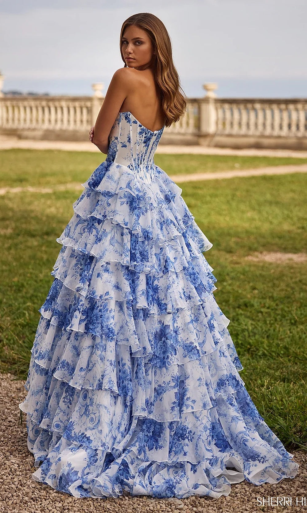 Sherri Hill 57250 ivory blue print prom dress back view with lace-up corset closure, tiered organza ruffle skirt with train, evening gown