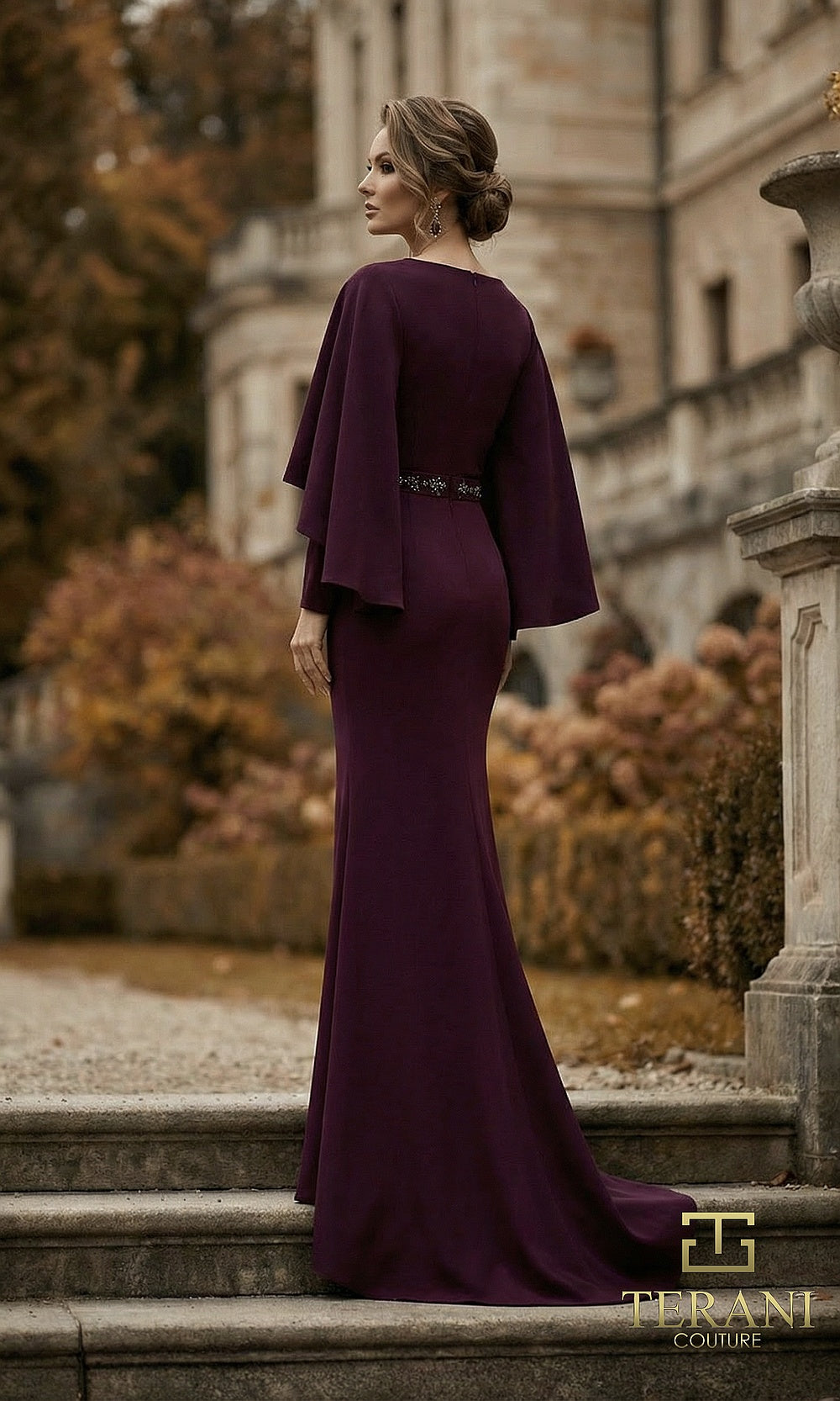 Terani Couture 262M7295 Aubergine mother of the bride dress back view with flowing cape, beaded belt, crepe column, formal wedding celebration dress